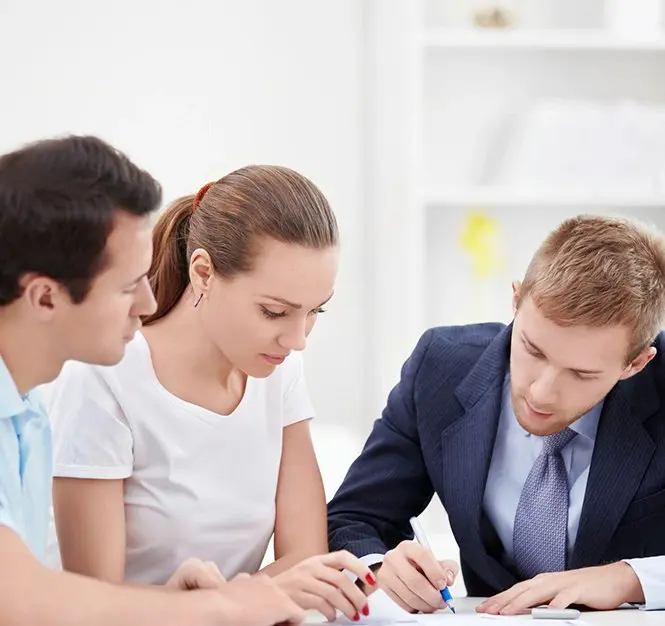 A man and two women are sitting at a table